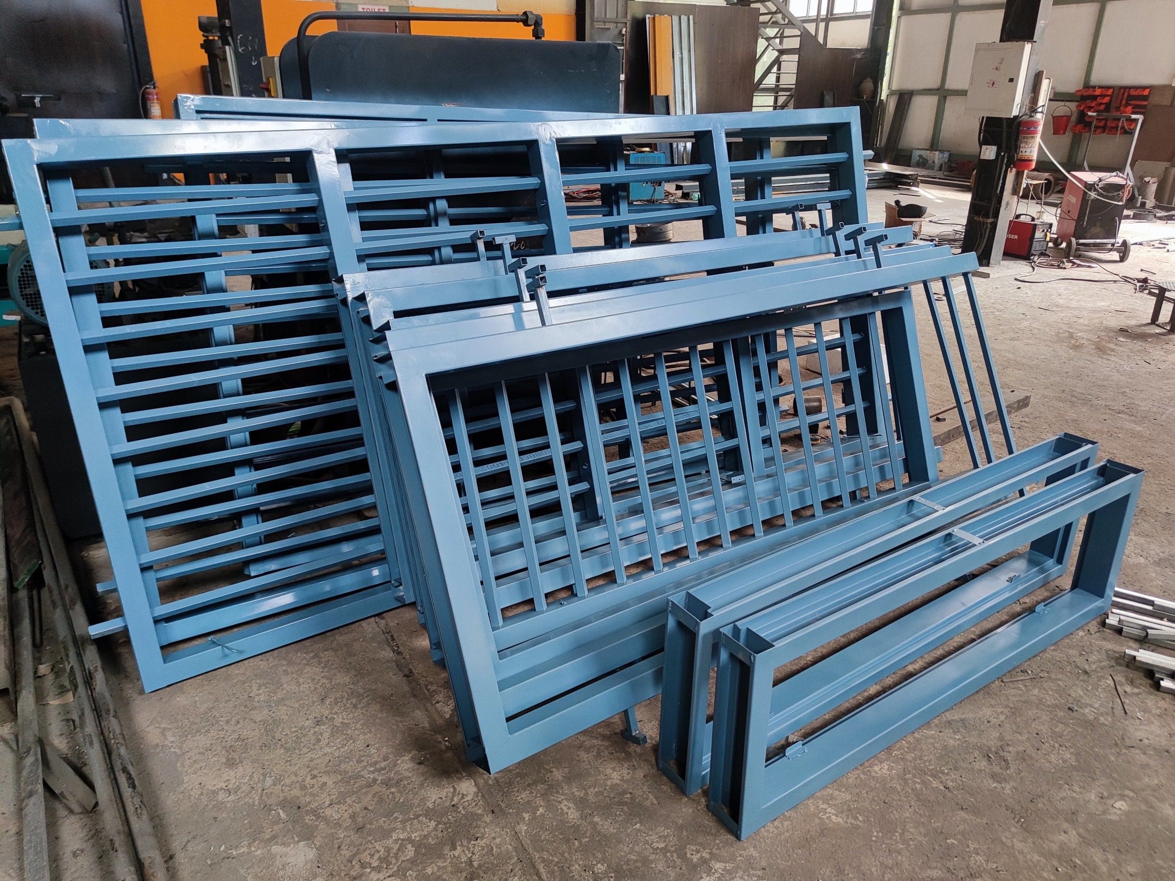 Finished blue steel window grilles and frames stacked in the plant